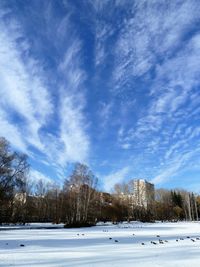 Snow covered landscape against blue sky