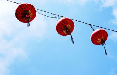 Low angle view of lanterns hanging against blue sky