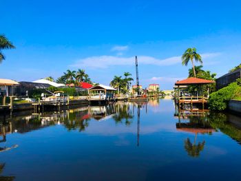 Houses by lake against blue sky