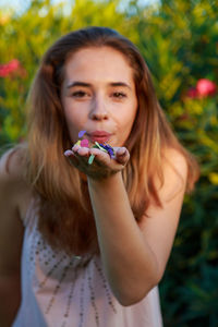 Portrait of young woman blowing confetti