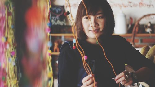 Portrait of smiling young woman holding camera