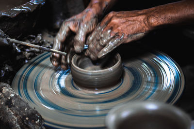 Cropped hands of man making pottery in workshop