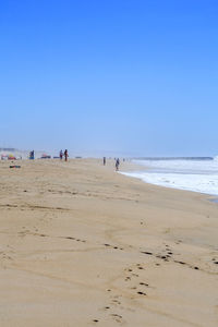 Scenic view of beach against clear blue sky