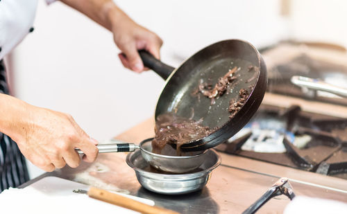 Midsection of man preparing food in kitchen