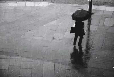 Woman with umbrella standing in rain