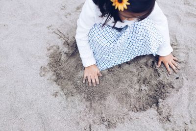 High angle view of hands on sand