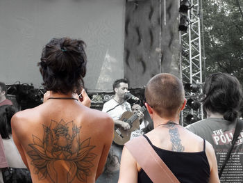 Rear view of people standing against buildings