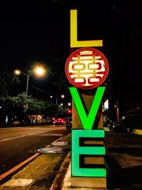 Illuminated road sign at night