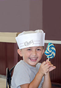 Smiling boy with giant lollipop at a candy shop