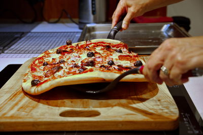 Cropped hand of person preparing food on table