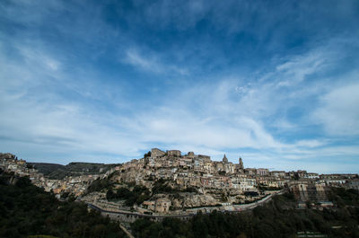 Low angle view of houses on mountain against sky