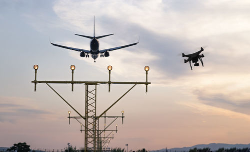 Low angle view of silhouette airplane against sky during sunset