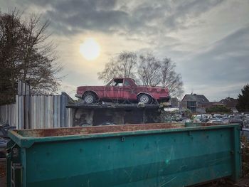 Abandoned car against sky during sunset