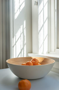 Close-up of fruits and bowl on table at home