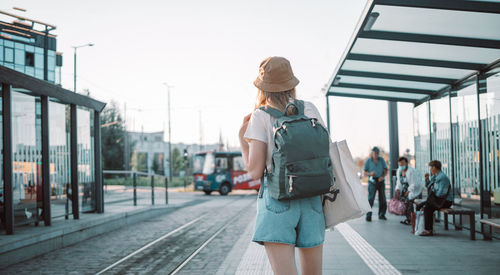 Rear view of woman walking on road in city