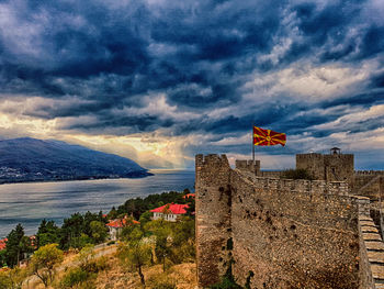 Scenic view of sea by buildings against sky