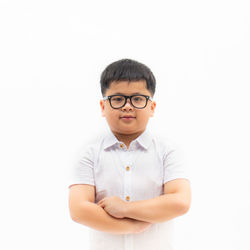 Portrait of boy standing against white background