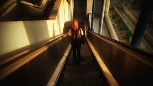 Rear view of woman standing on steps