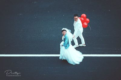 Young couple standing against white wall