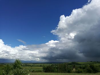 Scenic view of grassy field against cloudy sky