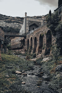 Arch bridge over old building against sky