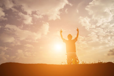 Rear view of silhouette man standing against sky during sunset