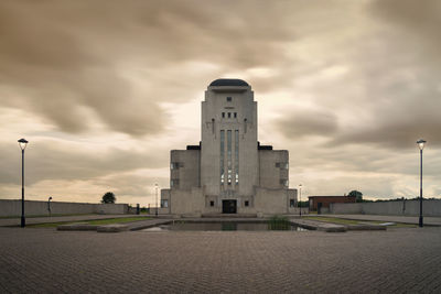 Buildings in city against cloudy sky