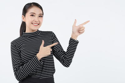 Portrait of smiling woman standing against white background