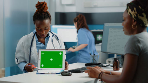 Doctor showing digital tablet in office