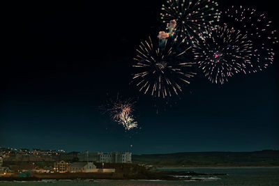 Low angle view of firework display in sky at night