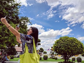 Woman standing by plants against sky