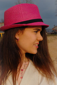 Close-up of beautiful young woman in hat looking away