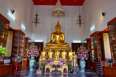 Statue against illuminated building in temple