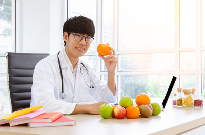 Portrait of woman with fruits on table