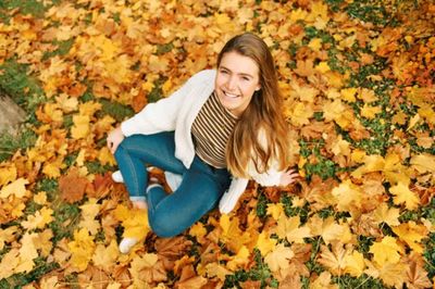 Portrait of young woman sitting on field