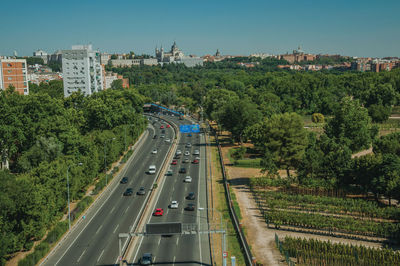 Multi-lane highway with heavy traffic in the midst of trees and buildings in madrid, spain.