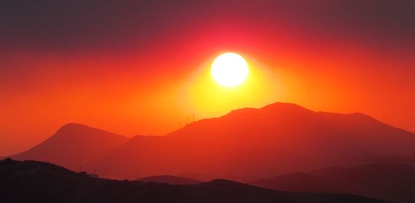 Scenic view of silhouette mountains against romantic sky at sunset
