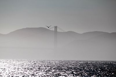 Golden gate bridge over san francisco bay against mountains during foggy weather