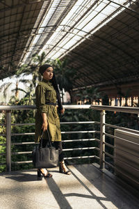 Full length of young woman standing in factory