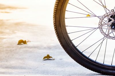 Bicycle wheel on beach against sky