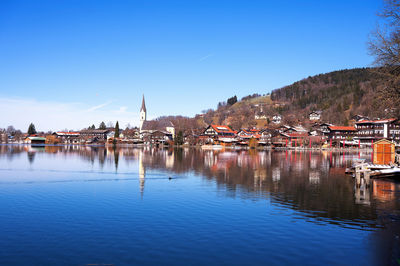 Buildings by river against sky in town