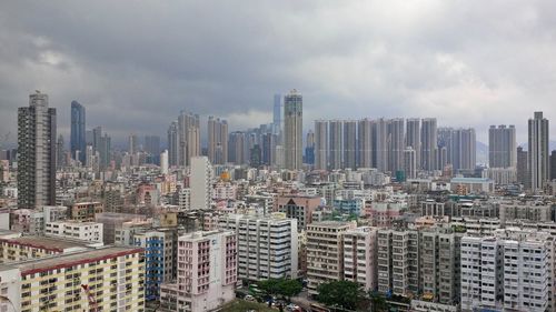 Aerial view of buildings in city against sky