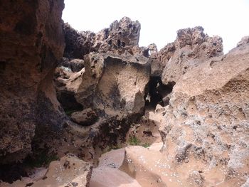 Low angle view of rock formation on land against sky