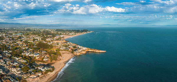 High angle view of city by sea against sky