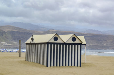 Lifeguard hut on beach against sky