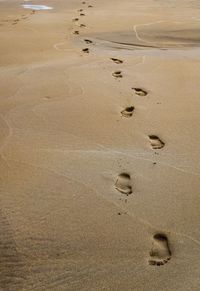 High angle view of footprints on sand at beach