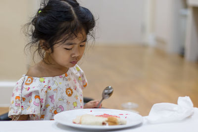 Cute girl looking away in plate on table