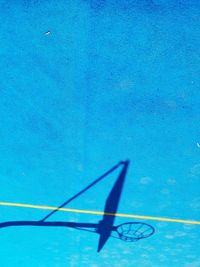 High angle view of umbrella over sea against blue wall