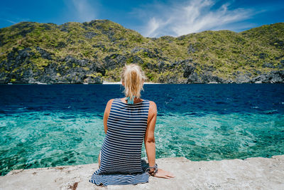 Rear view of woman looking at sea against sky