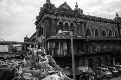 Low angle view of statues on building against sky